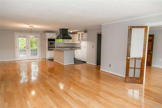 kitchen featuring white cabinets, dark countertops, glass insert cabinets, island exhaust hood, and french doors