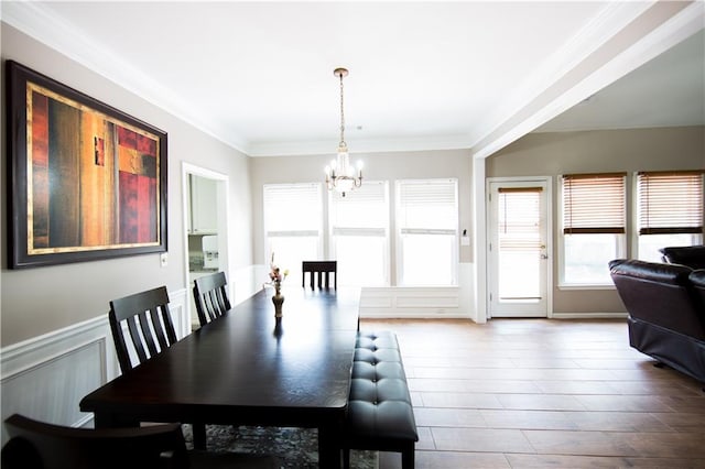 dining room with a notable chandelier, ornamental molding, and hardwood / wood-style flooring