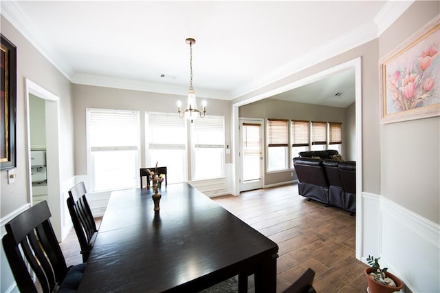 dining area featuring crown molding, a chandelier, and hardwood / wood-style flooring