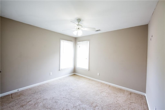 carpeted spare room featuring ceiling fan