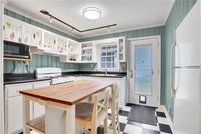 kitchen featuring tile patterned floors, wood counters, white appliances, open shelves, and a sink