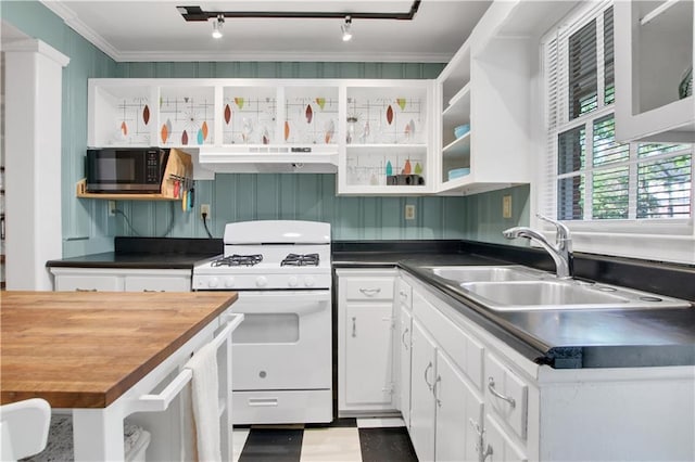 kitchen featuring white gas stove, black microwave, white cabinets, under cabinet range hood, and a sink