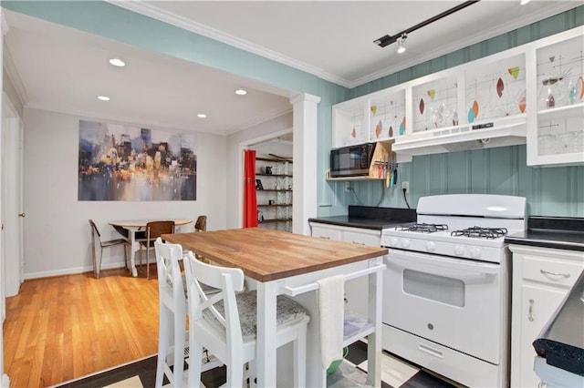 kitchen with black microwave, crown molding, white range with gas stovetop, under cabinet range hood, and butcher block counters