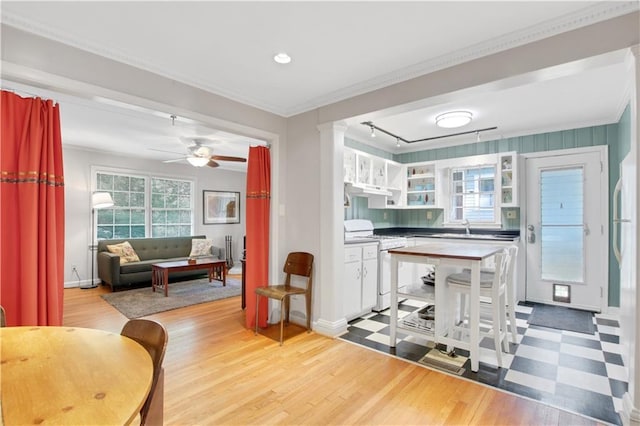 kitchen featuring light wood-type flooring, baseboards, white gas stove, open shelves, and a sink