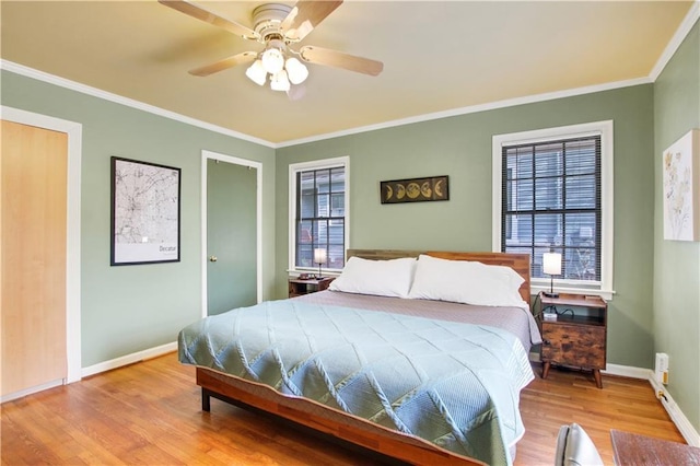 bedroom with baseboards, crown molding, a ceiling fan, and wood finished floors