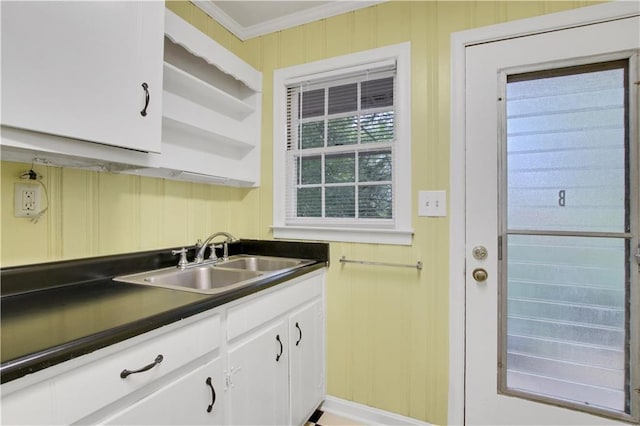 kitchen featuring ornamental molding, open shelves, dark countertops, white cabinets, and a sink
