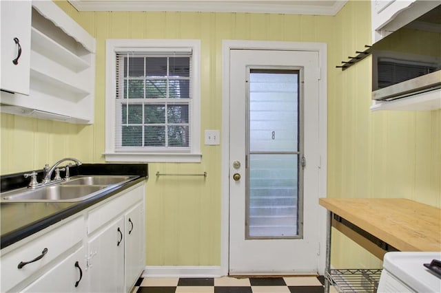 doorway featuring a sink, ornamental molding, and tile patterned floors