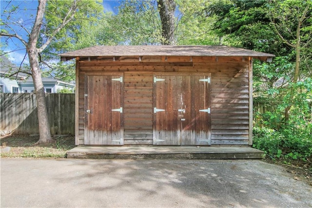 view of shed featuring fence