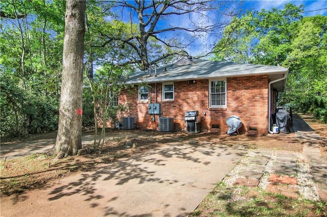 rear view of house with brick siding and cooling unit