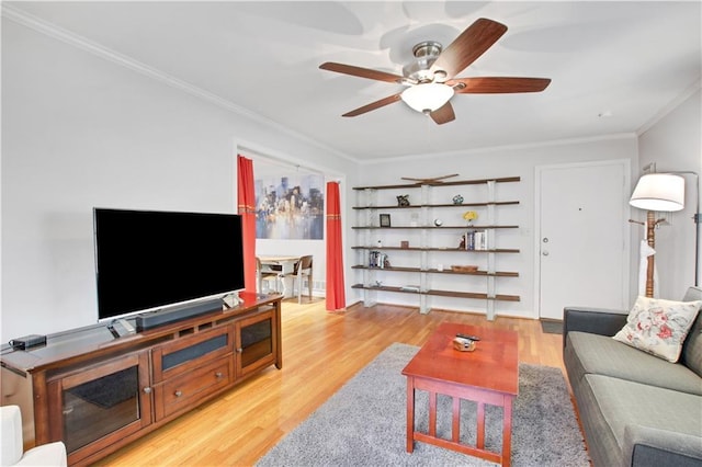 living area with light wood-type flooring, crown molding, and a ceiling fan