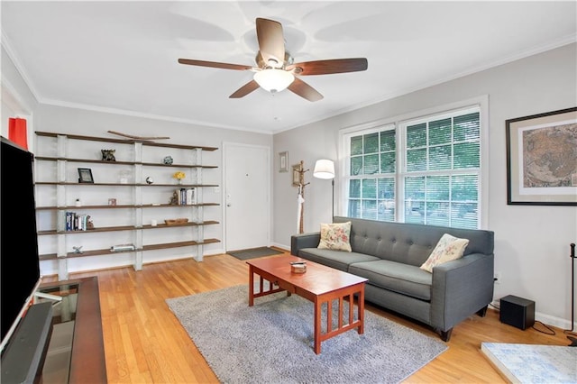 living room with light wood-style floors, ornamental molding, and a ceiling fan