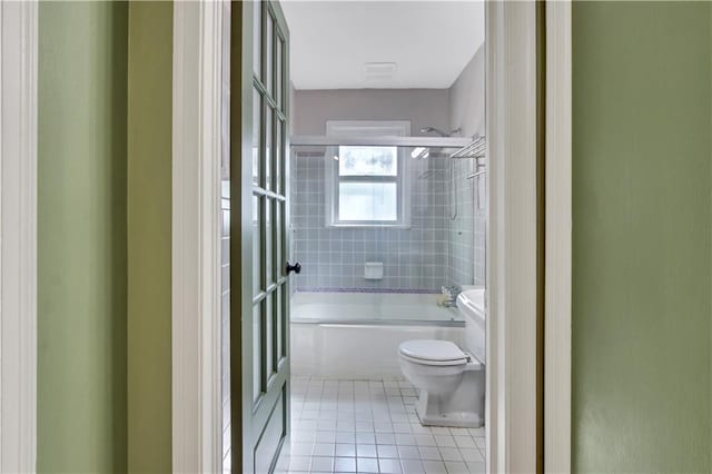 bathroom featuring toilet, bathing tub / shower combination, and tile patterned flooring