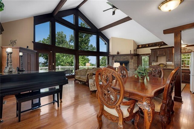 dining area featuring ceiling fan, light hardwood / wood-style flooring, high vaulted ceiling, and beamed ceiling