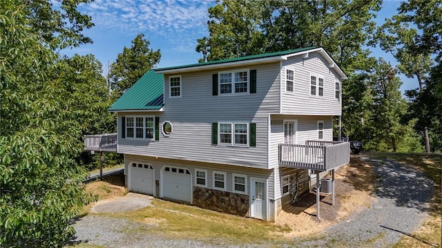 view of front of house featuring central air condition unit, a deck, and a garage