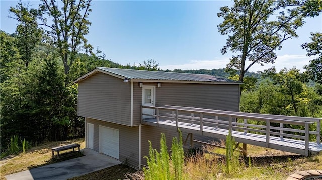 back of house with a garage and a deck