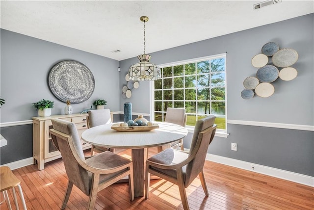 70 Lake Charles Xing, Covington, GA 30016 - dining space with light wood-type flooring, baseboards, and a chandelier