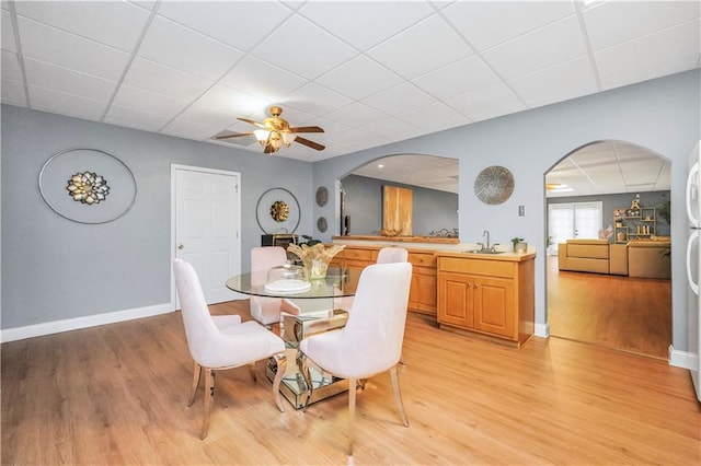 70 Lake Charles Xing, Covington, GA 30016 - dining space featuring a paneled ceiling, arched walkways, baseboards, light wood-style flooring, and ceiling fan