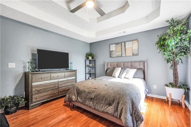 70 Lake Charles Xing, Covington, GA 30016 - bedroom with a tray ceiling, wood finished floors, a ceiling fan, and baseboards