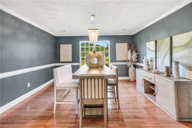 70 Lake Charles Xing, Covington, GA 30016 - dining area with light wood finished floors, baseboards, a textured ceiling, a chandelier, and ornamental molding