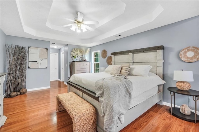 70 Lake Charles Xing, Covington, GA 30016 - bedroom featuring a tray ceiling, baseboards, wood finished floors, and a ceiling fan