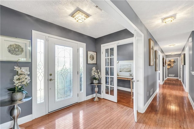 70 Lake Charles Xing, Covington, GA 30016 - entrance foyer featuring hardwood / wood-style floors, plenty of natural light, baseboards, a textured ceiling, and french doors