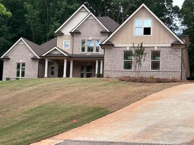 4563 Fawn Path, Gainesville, GA 30506 - craftsman inspired home featuring brick siding, board and batten siding, a front lawn, and a porch