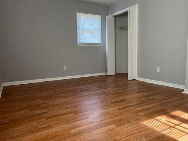 unfurnished bedroom featuring baseboards and wood finished floors