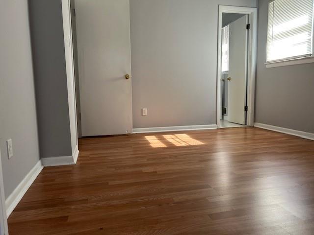 unfurnished bedroom with baseboards and wood finished floors