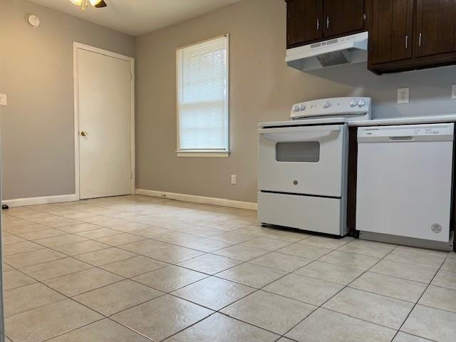 kitchen with white appliances, dark brown cabinetry, under cabinet range hood, and light tile patterned floors
