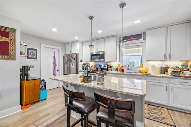 312 Glen Iris Dr, Monroe, GA 30655 - kitchen with appliances with stainless steel finishes, light wood-type flooring, a breakfast bar, white cabinets, and recessed lighting
