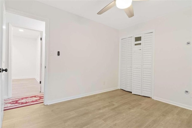 unfurnished bedroom with light wood-type flooring, ceiling fan, and a closet