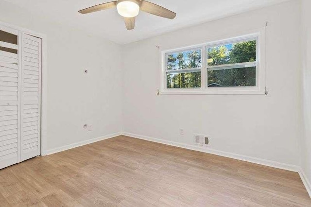 unfurnished bedroom with light hardwood / wood-style flooring, a closet, and ceiling fan