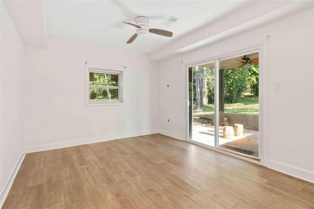 empty room with a wealth of natural light, light hardwood / wood-style floors, and ceiling fan