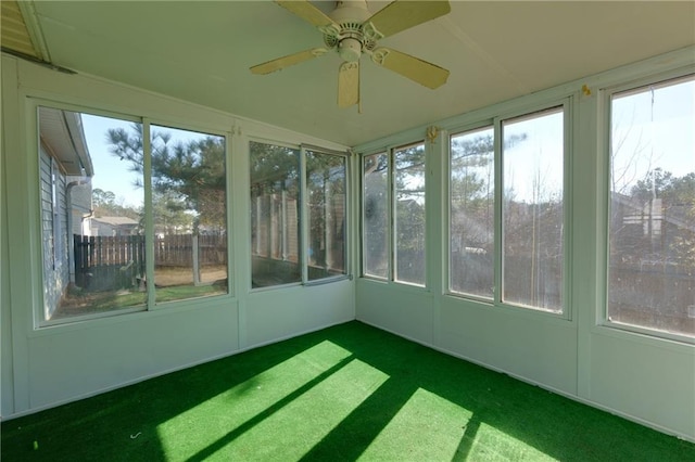 unfurnished sunroom with a ceiling fan and plenty of natural light