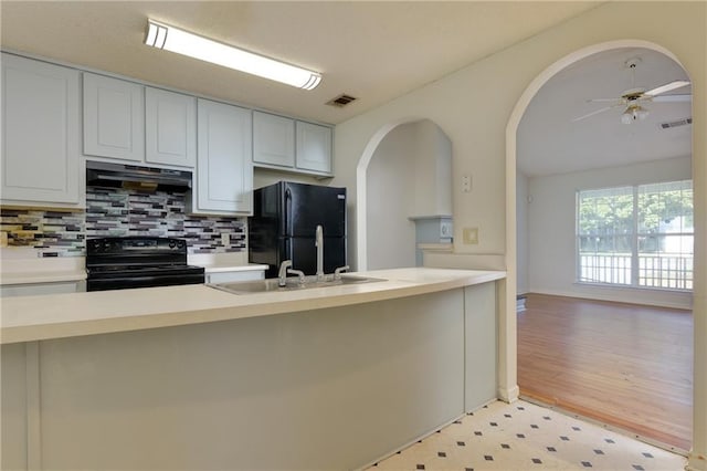 kitchen with black appliances, visible vents, light countertops, and ventilation hood