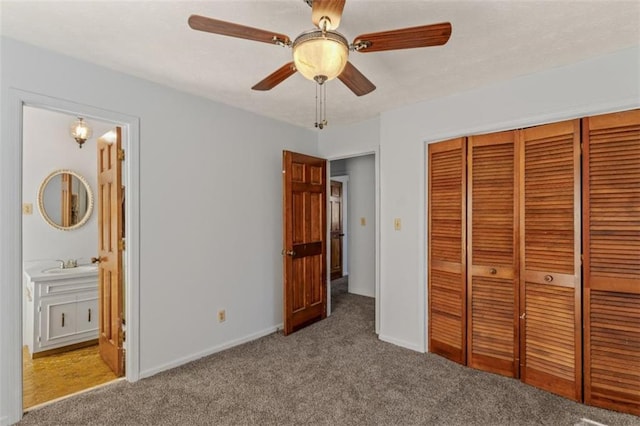 unfurnished bedroom featuring light carpet, sink, ceiling fan, connected bathroom, and a closet