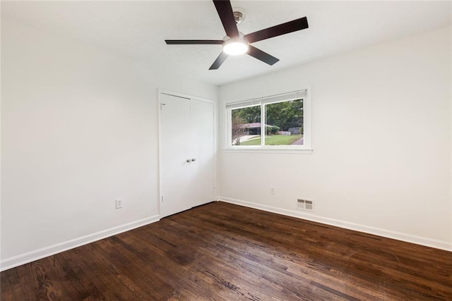 empty room featuring ceiling fan and dark wood-type flooring