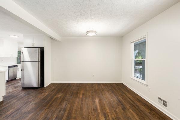 empty room with dark hardwood / wood-style floors and a textured ceiling