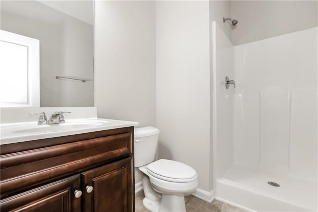 bathroom featuring tile patterned flooring, vanity, toilet, and walk in shower