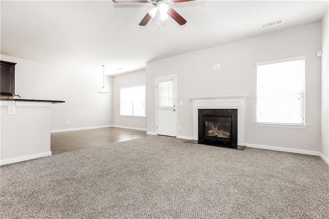 unfurnished living room with carpet floors and ceiling fan