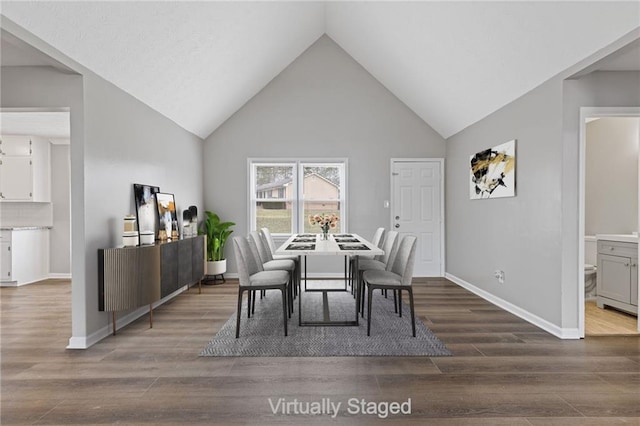 dining room featuring wood-type flooring and high vaulted ceiling