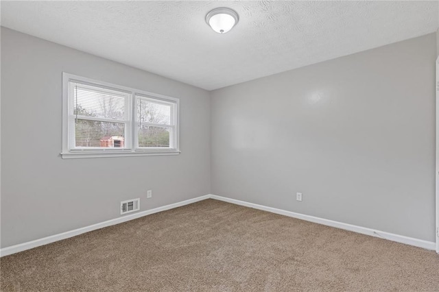 carpeted empty room featuring a textured ceiling