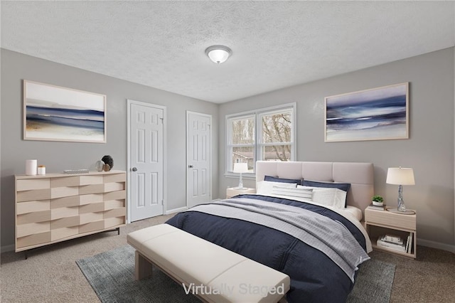 carpeted bedroom with multiple closets and a textured ceiling