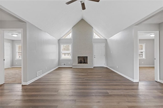 unfurnished living room featuring dark hardwood / wood-style flooring, high vaulted ceiling, ceiling fan, and a fireplace