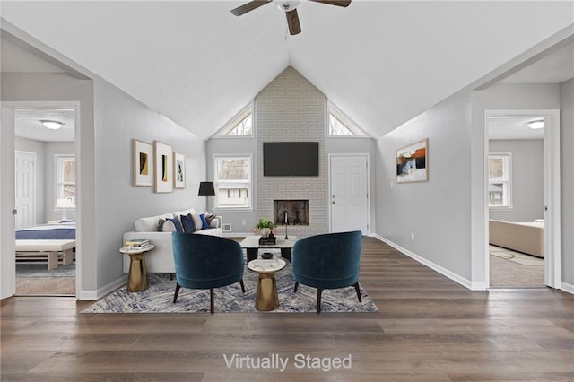 living room featuring lofted ceiling, hardwood / wood-style flooring, a fireplace, and ceiling fan