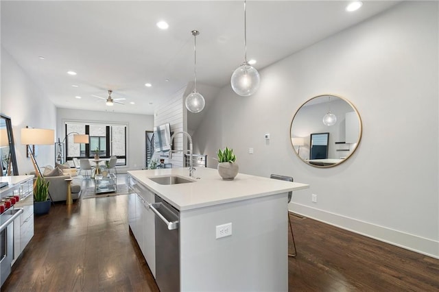 kitchen with dark wood-style floors, a kitchen island with sink, a sink, and modern cabinets