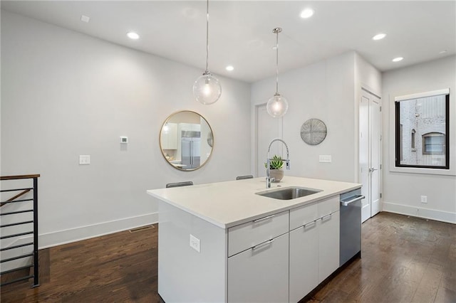 kitchen featuring white cabinets, stainless steel dishwasher, dark wood-style flooring, and a sink