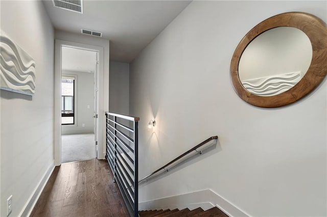 stairs with visible vents, baseboards, and wood finished floors