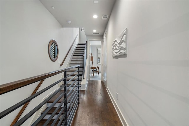 hall featuring recessed lighting, dark wood-style flooring, visible vents, and baseboards