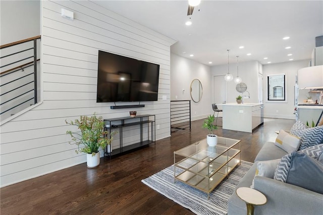 living area with baseboards, wood finished floors, and recessed lighting